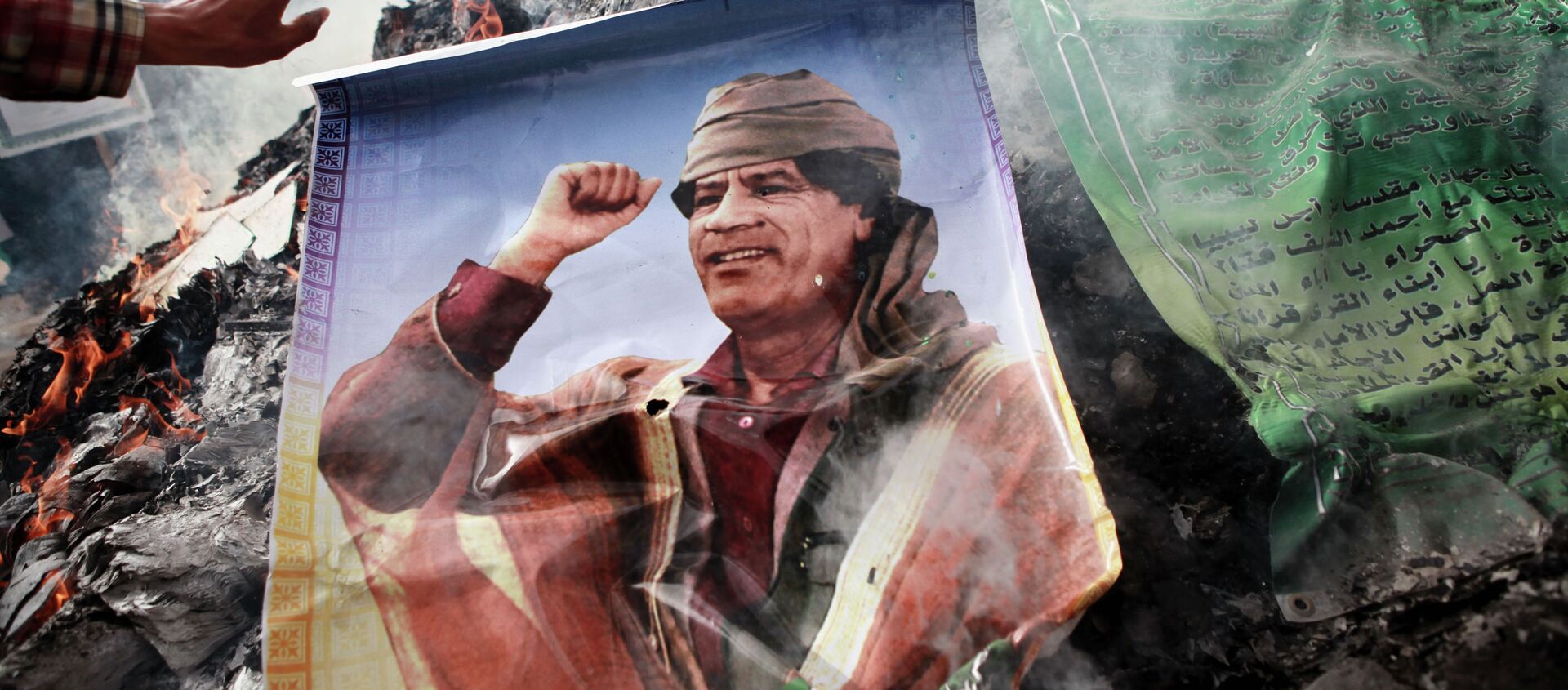 Жители Бенгази сжигают портреты Муамара Каддафи, плакаты с его цитатами и Зеленую книгу Каддафи.  - 俄罗斯卫星通讯社, 1920, 15.02.2021