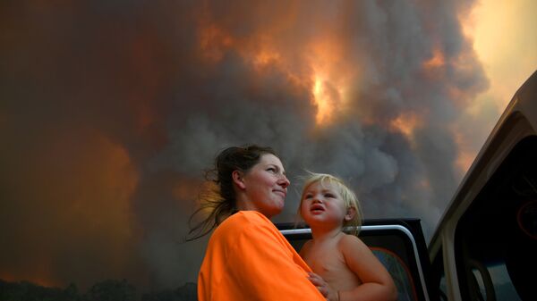 澳大利亚自然火灾的烟雾中抱着孩子的女子 - 俄罗斯卫星通讯社