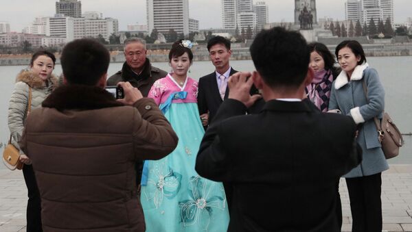 Молодожены во время свадебной фотосессии со своими родственниками в Пхеньяне - 俄罗斯卫星通讯社