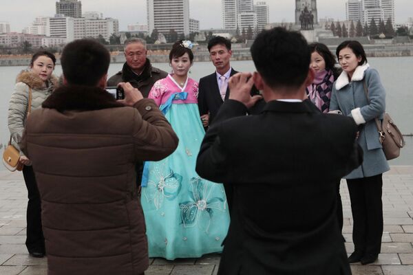 Молодожены во время свадебной фотосессии со своими родственниками в Пхеньяне - 俄罗斯卫星通讯社