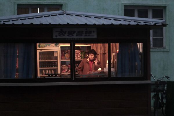 Продавец в киоске с закусками и напитками в Пхеньяне - 俄罗斯卫星通讯社