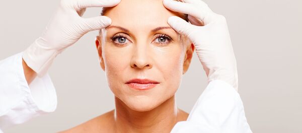 Косметолог осматривает кожу пациента - 俄罗斯卫星通讯社