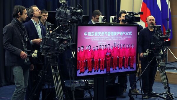 Журналисты у монитора с изображением трансляции церемонии начала поставок российского газа в КНР по восточному маршруту. - 俄罗斯卫星通讯社