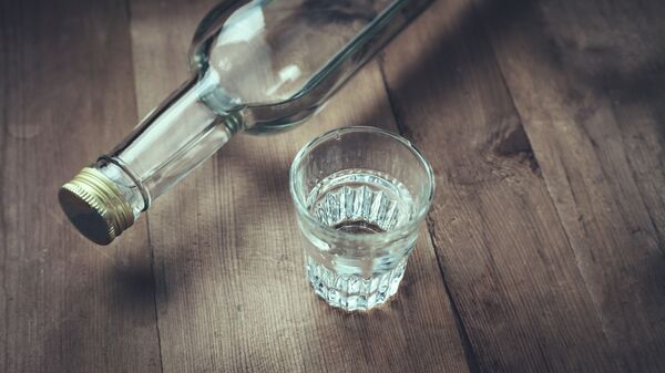 Бутылка и стакан водки на деревянном столе - 俄羅斯衛星通訊社