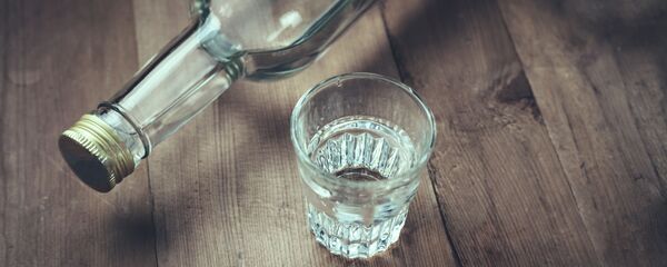 Бутылка и стакан водки на деревянном столе - 俄羅斯衛星通訊社
