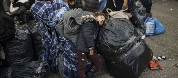 Ребенок спит во время подготовки к отъезду из импровизированного лагеря рядом с лагерем беженцев Мория на острове Лесбос - 俄罗斯卫星通讯社