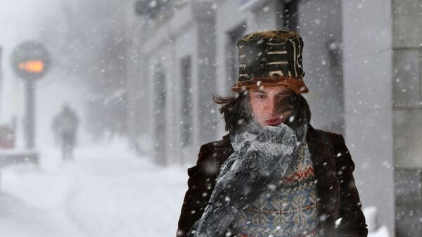 Молодой человек на улице во время снежной бури  - 俄罗斯卫星通讯社
