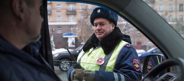 Сотрудник ГИБДД проверяет документы у водителя на Ленинградской площади в Омске - 俄罗斯卫星通讯社