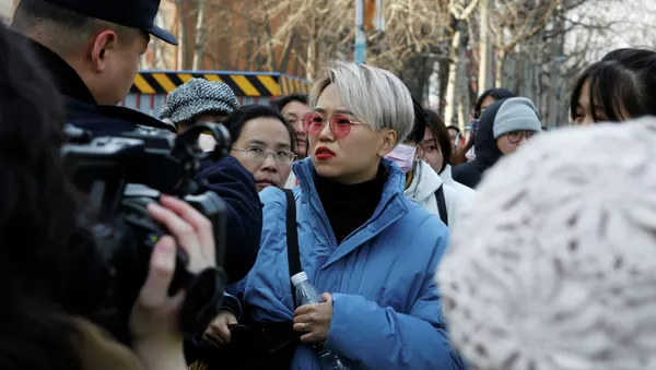 Teresa Xu, 31, speaks to a police officer outside Chaoyang People's Court after a court hearing of her suit against a Beijing hospital - 俄羅斯衛星通訊社