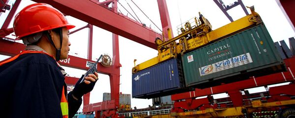 Рабочий следит за погрузкой контейнера в порту - 俄罗斯卫星通讯社