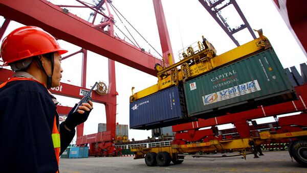 Рабочий следит за погрузкой контейнера в порту - 俄罗斯卫星通讯社