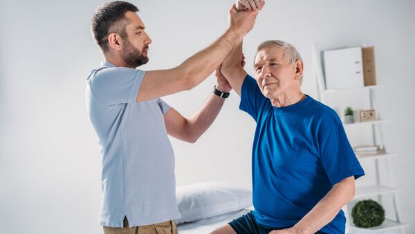 Терапевт делает массаж пожилому пациенту - 俄罗斯卫星通讯社