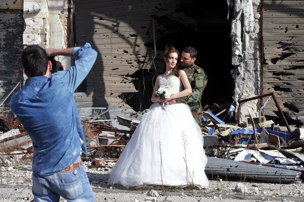Сирийские молодожены во время фотосессии на фоне разрушенных зданий в Хомсе  - 俄罗斯卫星通讯社