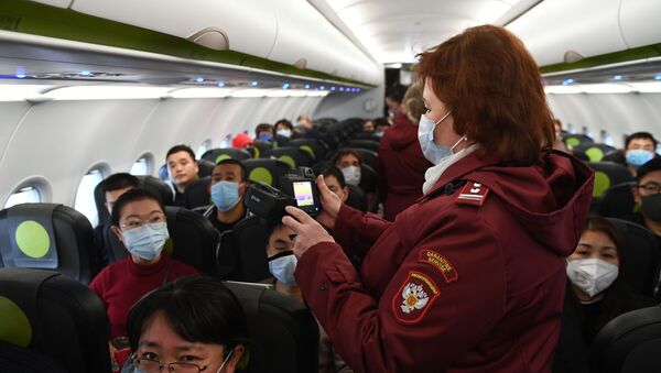 отрудники Роспотребназдора обследуют при помощи тепловизора пассажиров рейса авиакомпании S7, прибывшего из Пекина, в аэропорту Толмачево  - 俄罗斯卫星通讯社