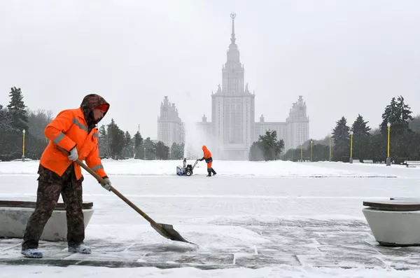 Сотрудники коммунальной службы во время уборки снега возле здания МГУ на Воробьевых горах в Москве