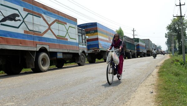 Женщина на велосипеде на фоне грузовиков. Непал - 俄罗斯卫星通讯社