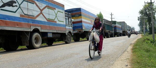 Женщина на велосипеде на фоне грузовиков. Непал - 俄羅斯衛星通訊社