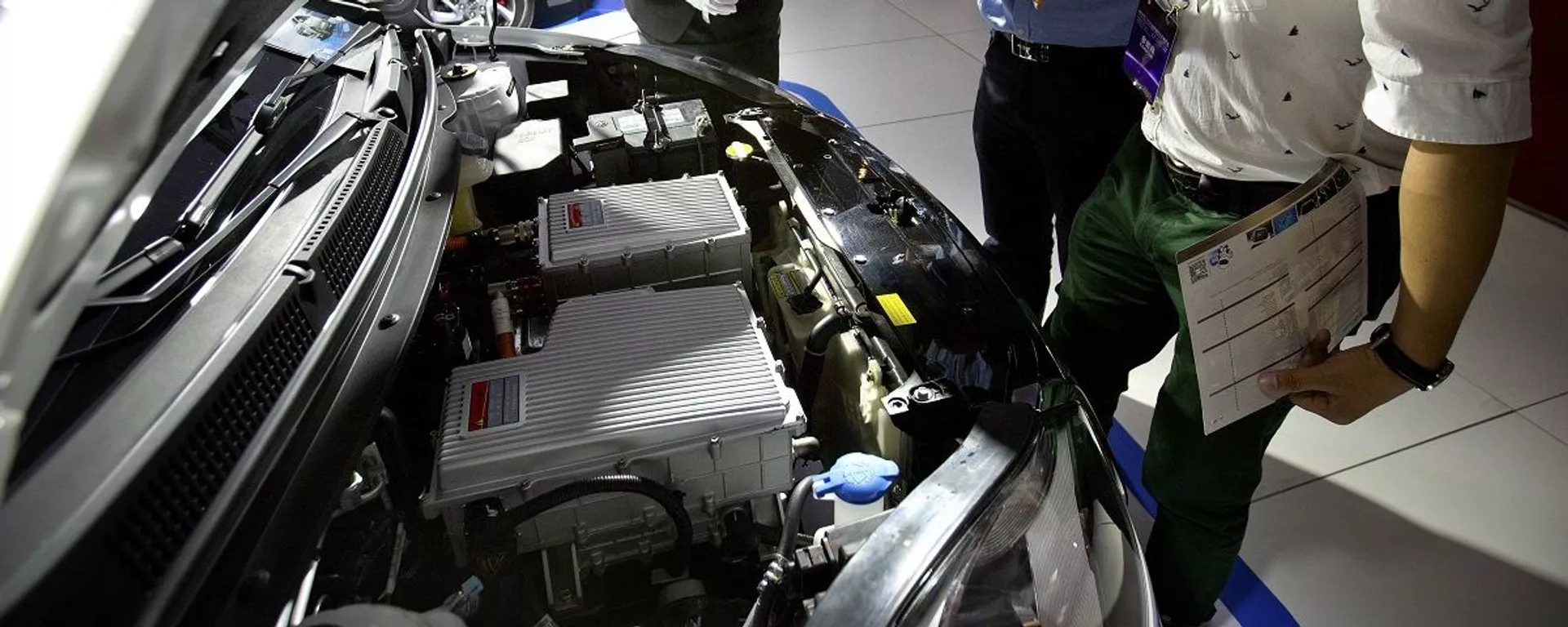 A staff member talks with visitors as they look over the motor of an iEV5 electric car from Chinese automaker JAC on display at the Beijing International Automotive Exhibition in Beijing, Monday, April 25, 2016. - 俄羅斯衛星通訊社, 1920, 02.11.2020
