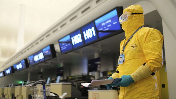 Работник в защитном костюме в аэропорту Уханя - 俄罗斯卫星通讯社
