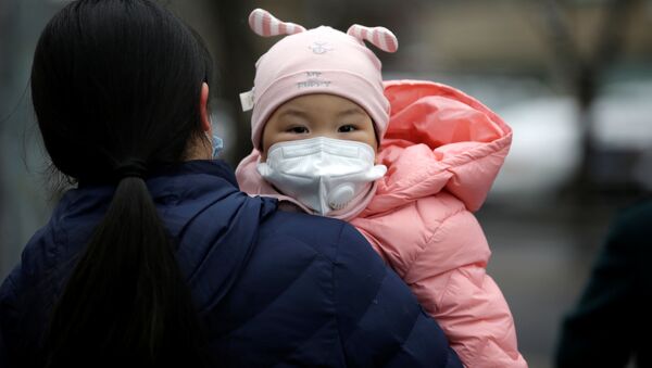 Женщина с ребенком в медицинских масках на одной из улиц Пекина - 俄罗斯卫星通讯社