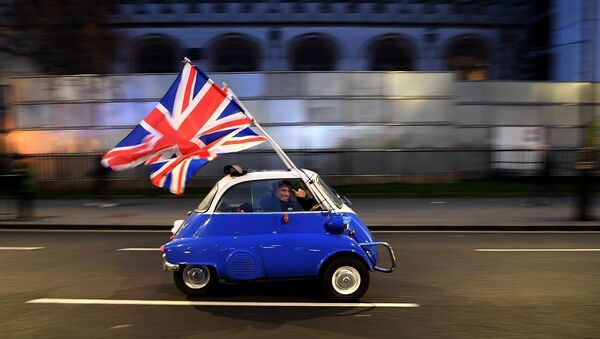 A man waves Union flags from a BMW Isetta as he drives past Brexit supporters gathering in Parliament Square, in central London on January 31, 2020, the day that the UK formally leaves the European Union.  - 俄罗斯卫星通讯社