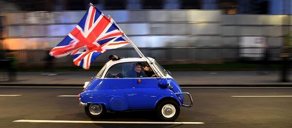 A man waves Union flags from a BMW Isetta as he drives past Brexit supporters gathering in Parliament Square, in central London on January 31, 2020, the day that the UK formally leaves the European Union.  - 俄罗斯卫星通讯社