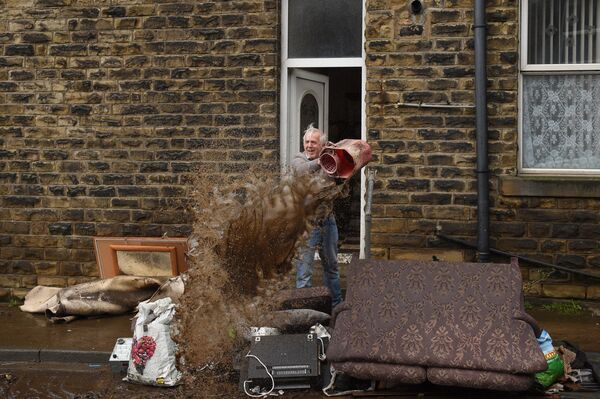 Мужчина чистит дом после наводнения в Северной Англии  - 俄羅斯衛星通訊社