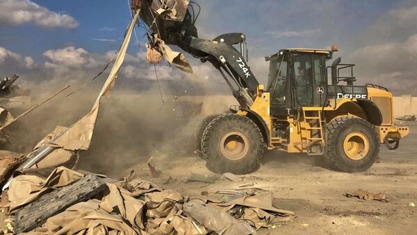 Бульдозер убирает обломки и мусор после обстрела военной базы США Эйн-аль-Асад в Ираке - 俄罗斯卫星通讯社