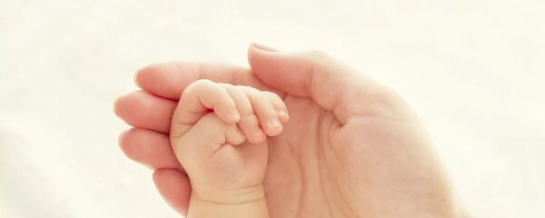 Рука ребенка и матери - 俄罗斯卫星通讯社