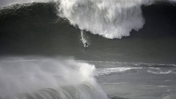 Серфер на гигантских волнах во время турнира Nazare Tow Surfing Challenge в Португалии  - 俄罗斯卫星通讯社