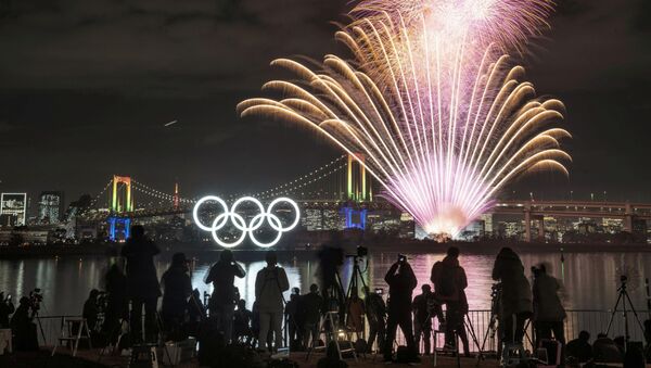Фейерверк около светящихся олимпийских колец в Токио - 俄羅斯衛星通訊社