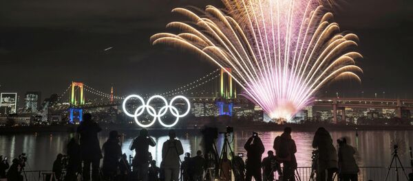 Фейерверк около светящихся олимпийских колец в Токио Фейерверк около светящихся олимпийских колец в Токио - 俄羅斯衛星通訊社