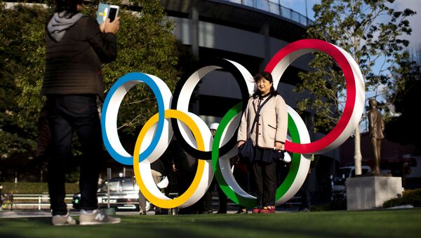 Женщины фотографируются на фоне олимпийских колец - 俄罗斯卫星通讯社