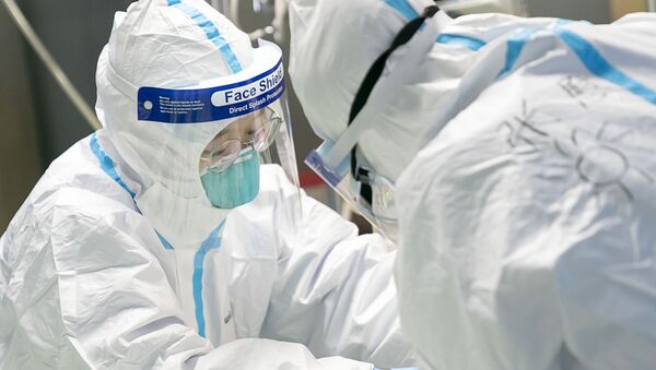 Медицинские работники в защитной одежде у пациента с коронавирусом в больнице Уханьского университета - 俄羅斯衛星通訊社