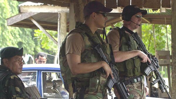 Two U.S. Army Special Forces clutch their M4 carbine beside their Filipino counterpart as they man a checkpoint at the entry of a military base - 俄羅斯衛星通訊社