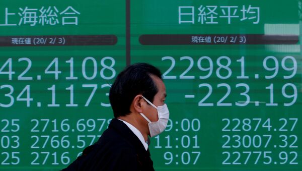 A man wearing a surgical mask walks past a screen showing Shanghai Composite index and Nikkei index outside a brokerage in Tokyo - 俄罗斯卫星通讯社