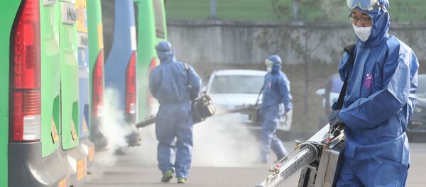 Работники службы дезинфекции распыляют дезинфицирующее средство в рамках профилактических мер против распространения коронавируса на автобусном терминале в Сеуле - 俄罗斯卫星通讯社