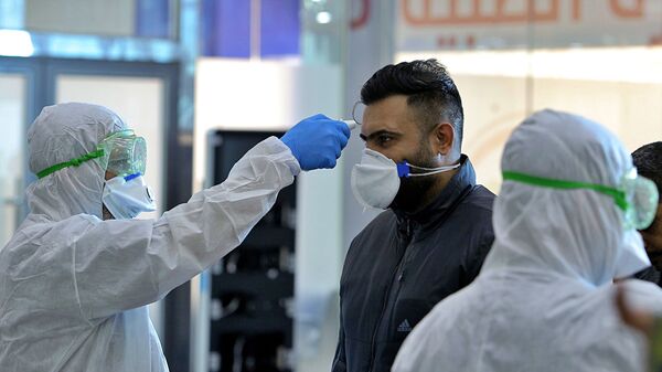Медицинский персонал проверяет пассажиров, прибывающих из Ирана, в аэропорту Наджафа, Ирак - 俄罗斯卫星通讯社