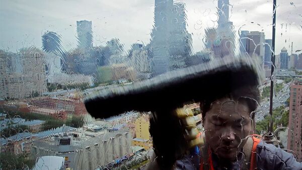Работник моет окно в офисного здания в деловом районе Пекина. - 俄羅斯衛星通訊社