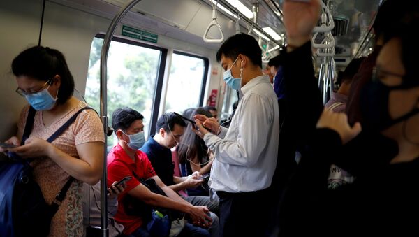 Люди в медицинских масках в общественном транспорте в Сингапуре - 俄罗斯卫星通讯社