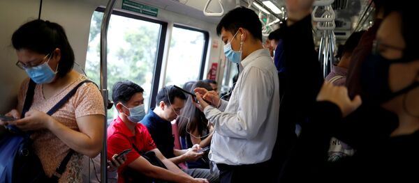 Люди в медицинских масках в общественном транспорте в Сингапуре - 俄罗斯卫星通讯社
