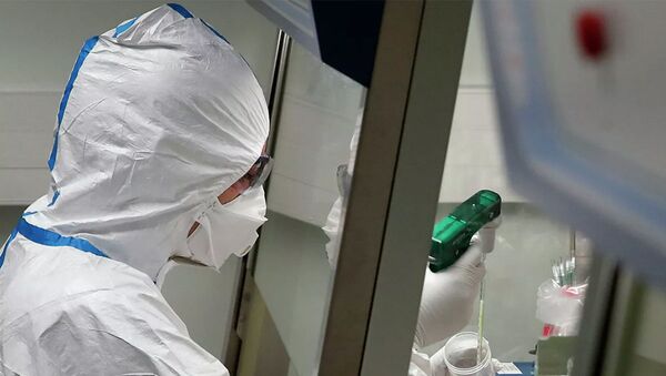 Работник лаборатории во Франции во время манипуляций с образцами пробы потенциально зараженного коронавирусом пациента  - 俄罗斯卫星通讯社