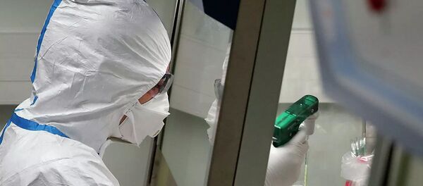 Работник лаборатории во Франции во время манипуляций с образцами пробы потенциально зараженного коронавирусом пациента  - 俄罗斯卫星通讯社