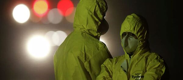 Военнослужащие в защитных костюмах во время прибытия граждан Бразилии из Китая на базе ВВС в Анаполисе - 俄羅斯衛星通訊社