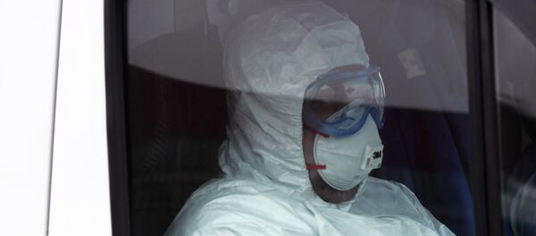 Медицинский сотрудник в маске и в защитном костюме Медицинский сотрудник в маске и в защитном костюме - 俄罗斯卫星通讯社