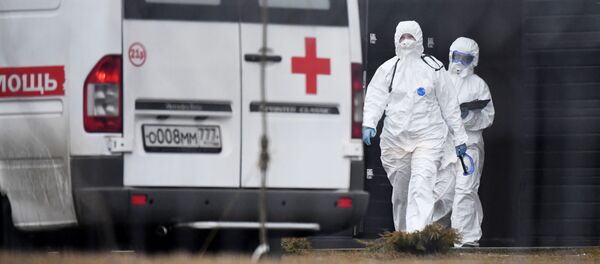 Сотрудники скорой помощи в защитных костюмах на территории больничного комплекса - 俄罗斯卫星通讯社