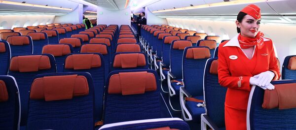 Стюардесса в салоне дальнемагистрального широкофюзеляжного пассажирского самолета Airbus A350-900 авиакомпании Аэрофлот - 俄罗斯卫星通讯社