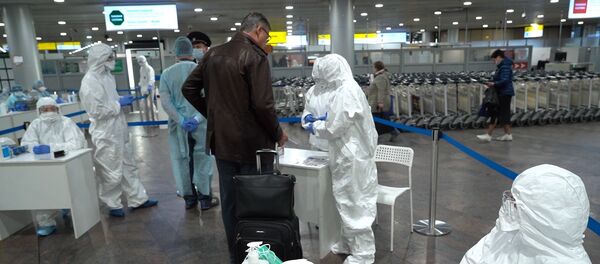 Медицинские работники проводят осмотр пассажиров в аэропорту Шереметьево.  - 俄罗斯卫星通讯社