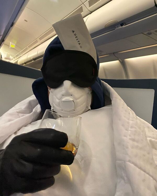 Актер Себастиан Стэн в защитном костюме и в маске во время полета на самолете - 俄羅斯衛星通訊社