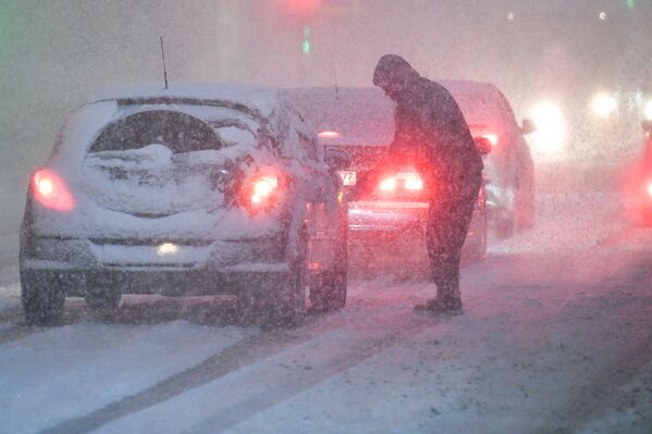一名男子清理被雪覆蓋的汽車 - 俄羅斯衛星通訊社